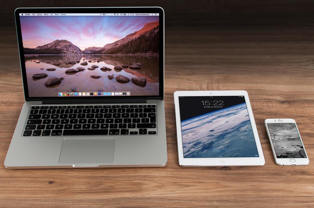 computer, tablet and phone on a wooden table